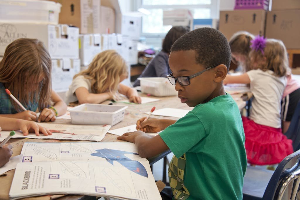 Image d’un enfant avec un cahier : TDAH et aménagement scolaire en Belgique.