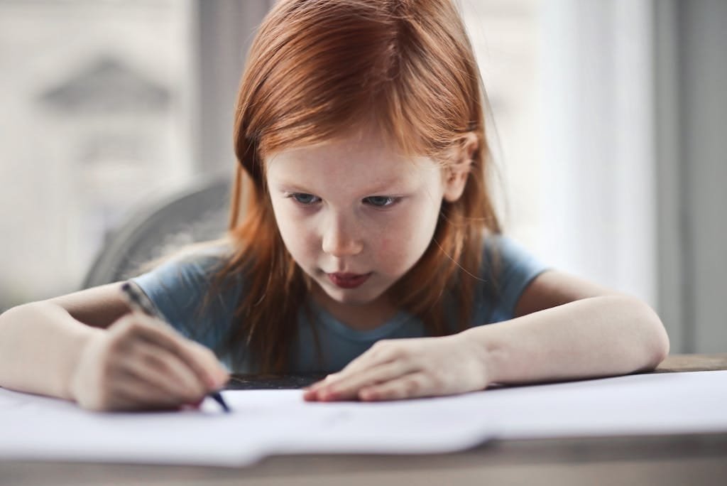 ENFANT TDAH qui se concentre sur ses devoirs et qui lutte contre hyperactivité