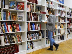 Une jeune femme à la bibliothèque, souffrant du TDAH (trouble déficitaire de l'attention avec hyperactivité), suivant un cursus universitaire dans une grande école.