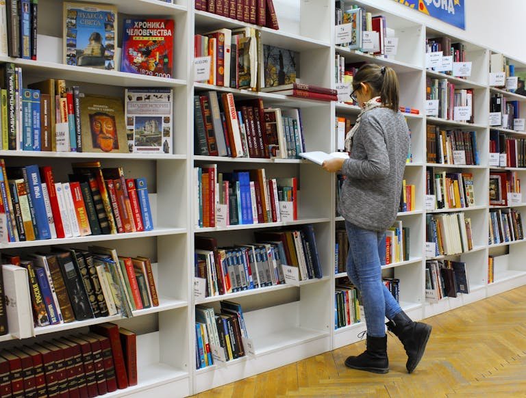 Une jeune femme à la bibliothèque, souffrant du TDAH (trouble déficitaire de l'attention avec hyperactivité), suivant un cursus universitaire dans une grande école.