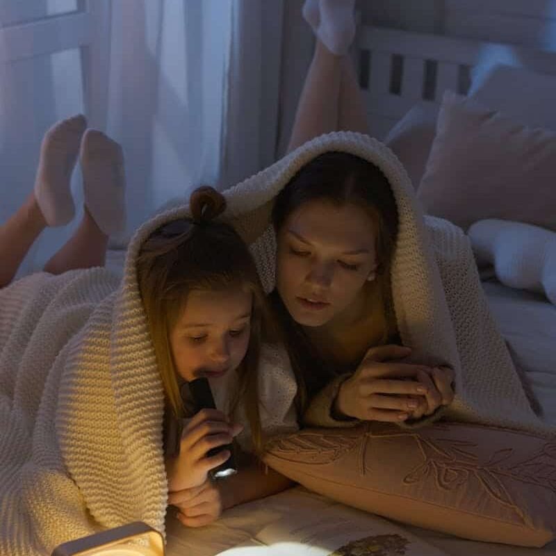 Parent qui lit une histoire à son enfant pour le rituel du coucher