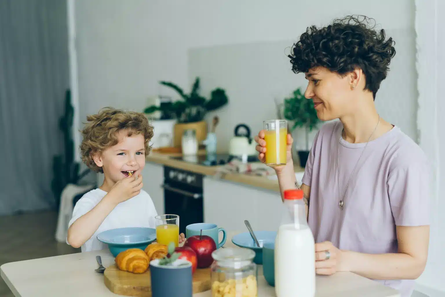 Mère et son jeune fils qui prennent le petit-déjeuner ensemble dans la cuisine