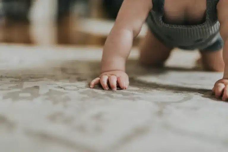 Bébé à quatre pattes, gros plan sur ses mains posées au sol