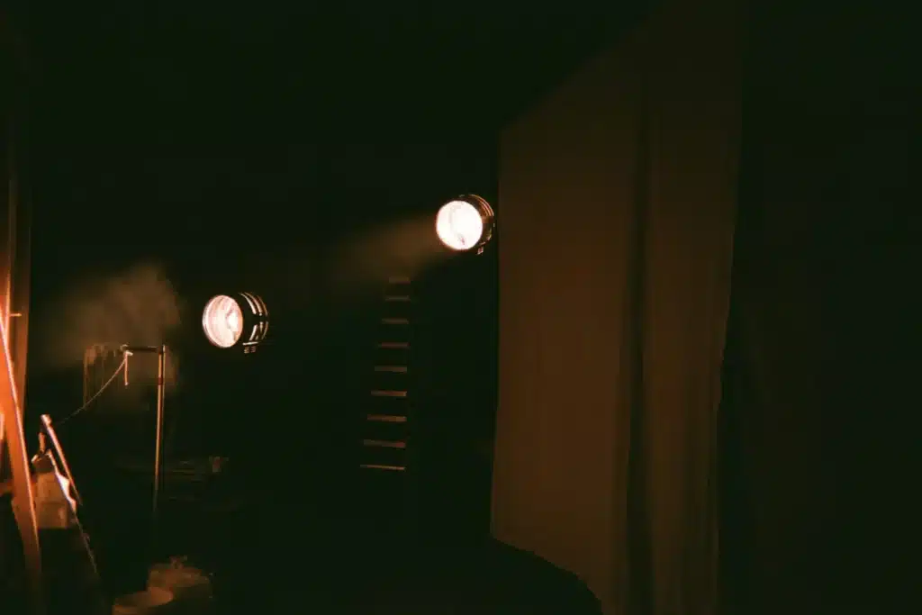 Scène vide éclairée par trois projecteurs avant un spectacle