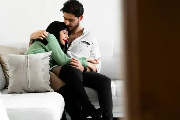 Couple enlacé sur un canapé, moment de tendresse et d'intimité