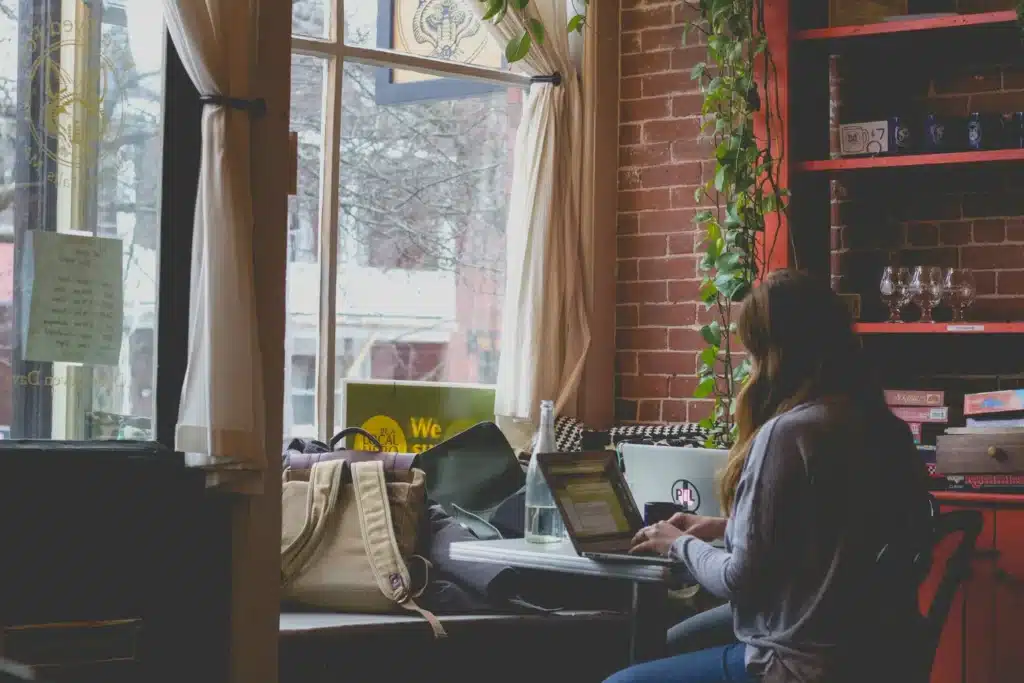 Femme qui travaille sur son ordinateur dans un café