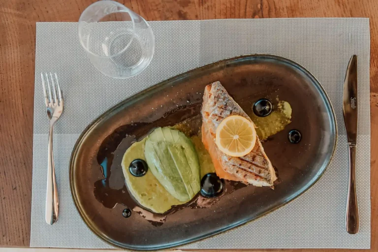 Filet de saumon et avocat dans une assiette, deux sources de bonnes graisses