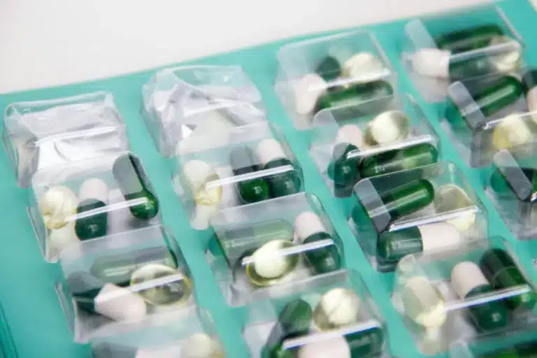 Gélules de médicaments rangées dans un pilulier transparent