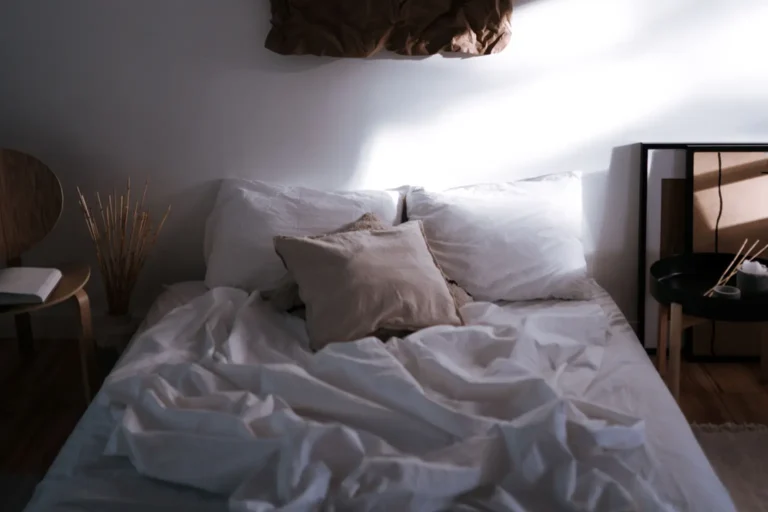 Lit défait dans une chambre sombre, après une nuit agitée