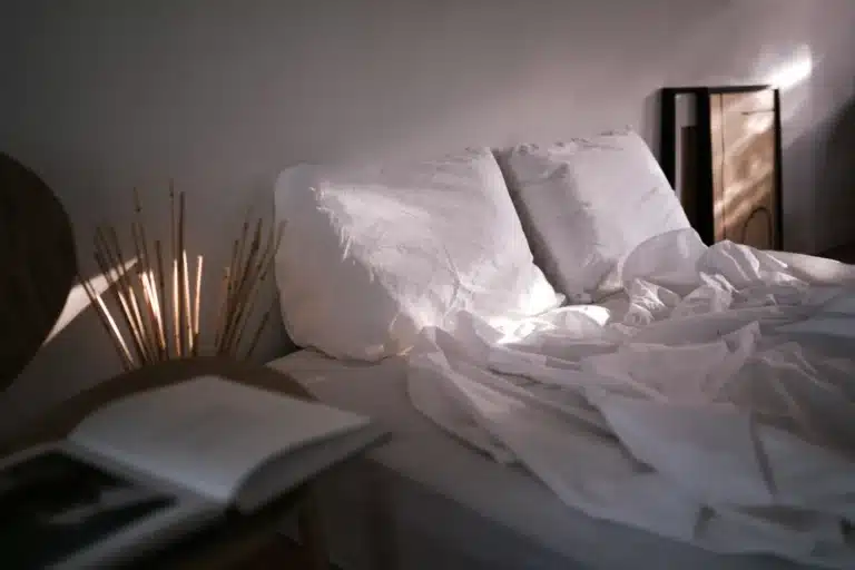 Lit défait et livre ouvert dans une chambre au petit matin
