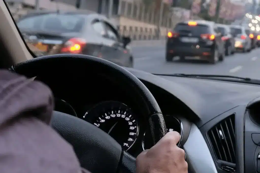 Mains d'un conducteur sur le volant, dans la circulation en ville