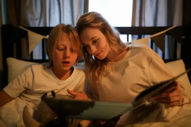 Mère et fils qui lisent une histoire ensemble dans le lit, avant de dormir