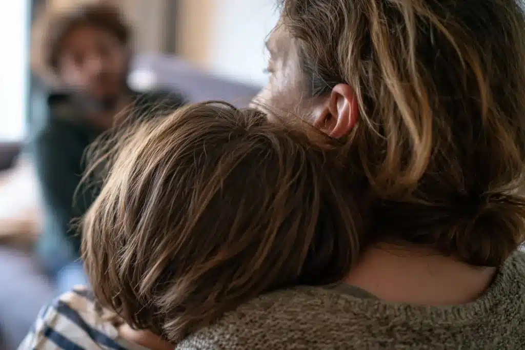 Mère qui serre son enfant contre elle pour l'apaiser