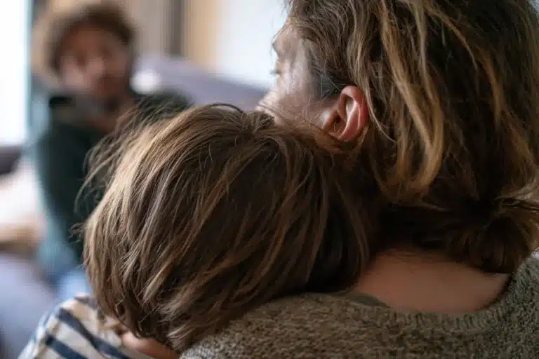Mère qui serre son enfant contre elle pour l'apaiser