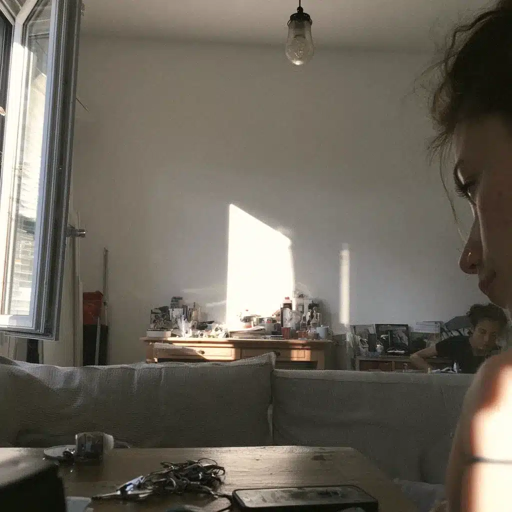 Une femme de profil, dans la lumière, le regard ailleurs, un bureau encombré derrière elle