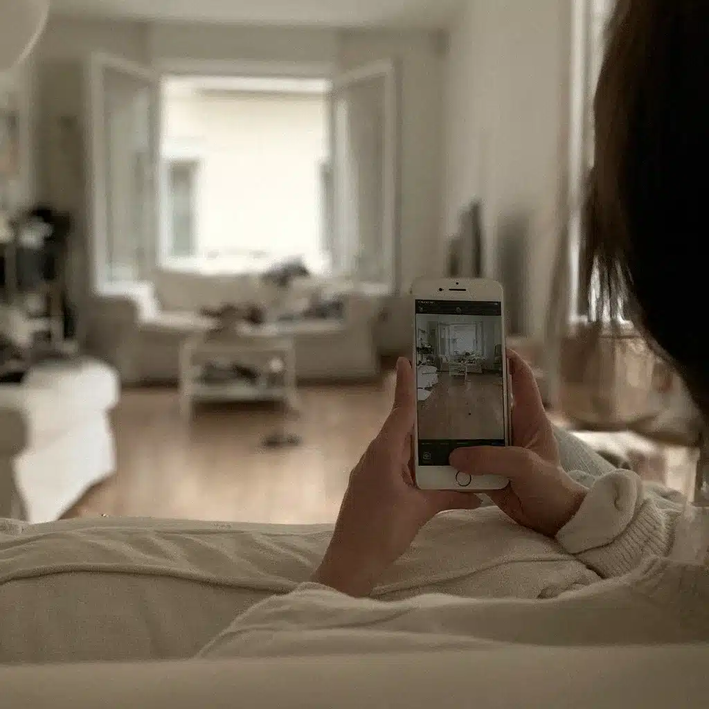 Une femme sur son canapé, le salon plus calme devant elle