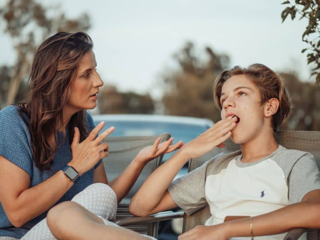Mère qui explique calmement pendant que son adolescent bâille, une tension parent-ado