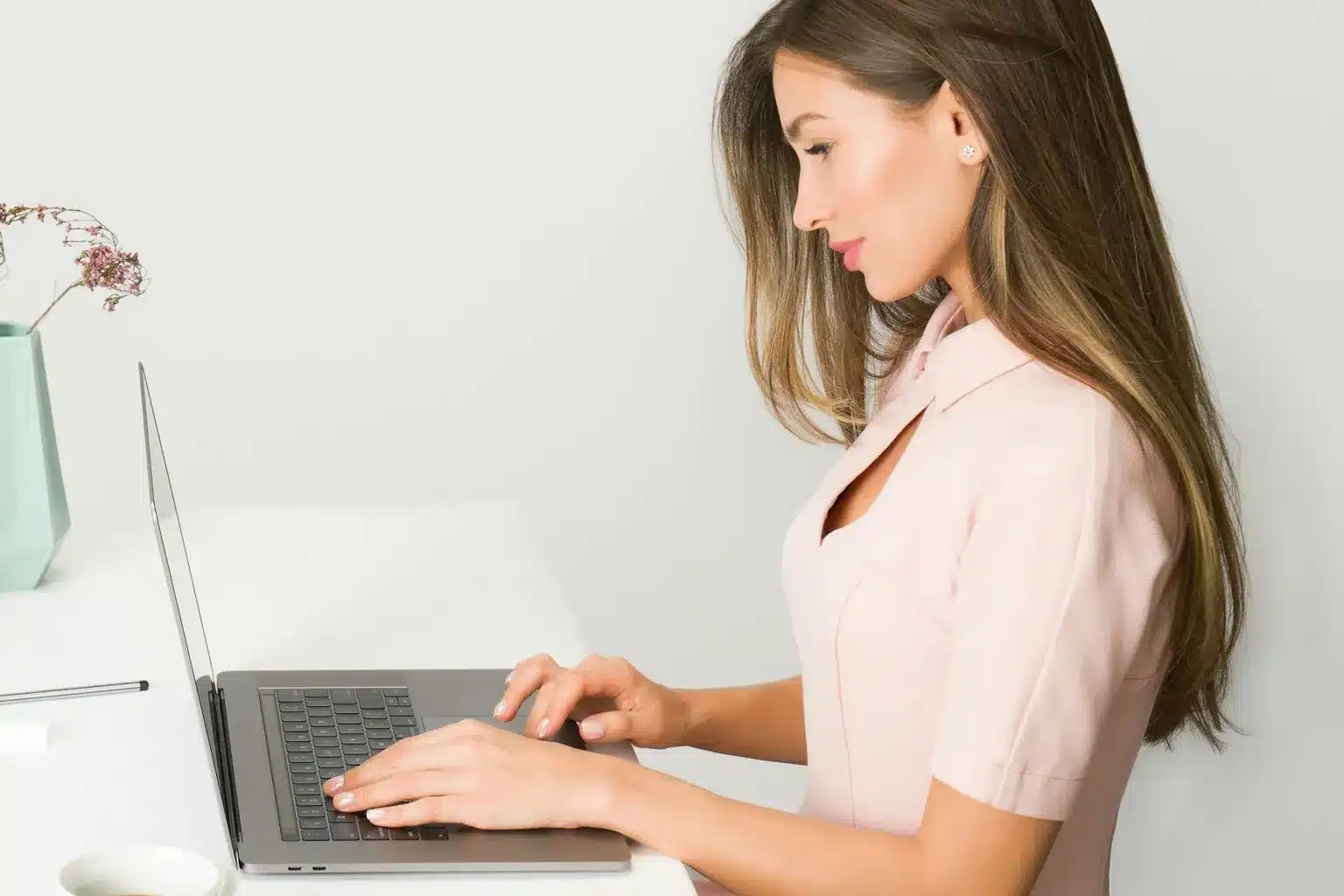 Femme qui travaille calmement sur son ordinateur à un bureau rangé et lumineux