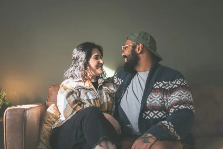 Couple assis sur un canapé, lumière douce de fin de journée