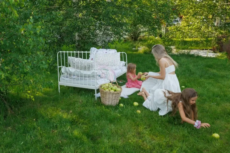 Une mère et ses deux filles ramassent des pommes dans un jardin en été